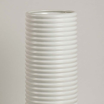 Closeup of white ceramic vase showing ribbed detailing and smooth handcrafted finish for minimalist artistic appeal.