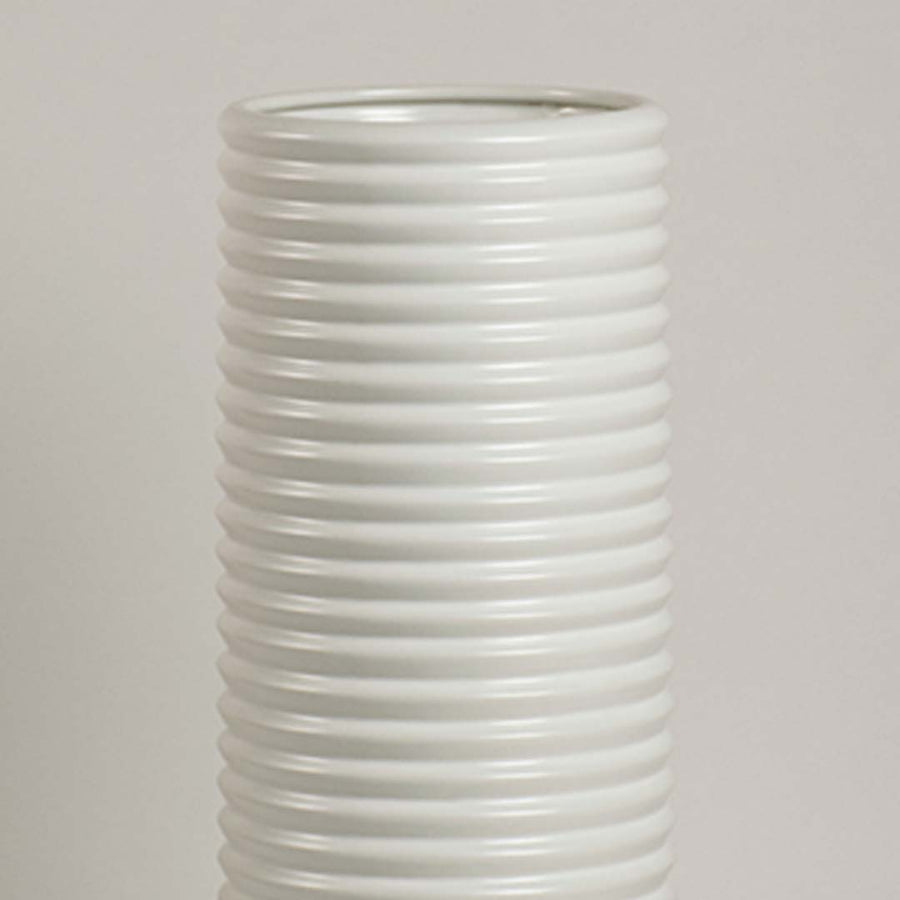 Closeup of white ceramic vase showing ribbed detailing and smooth handcrafted finish for minimalist artistic appeal.