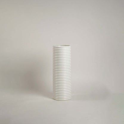 Matte white ceramic cylinder vase featuring a dense horizontal ribbed stacked texture on a clean white background.