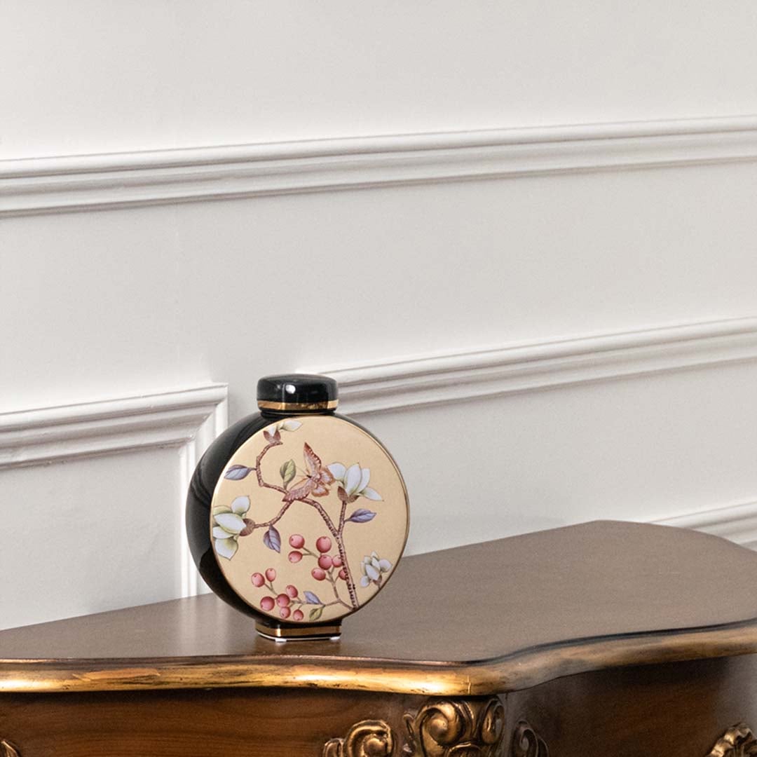 Black round ceramic jar with pastel floral artwork in a front view perfect for artistic décor styling and elegant tabletop placement.