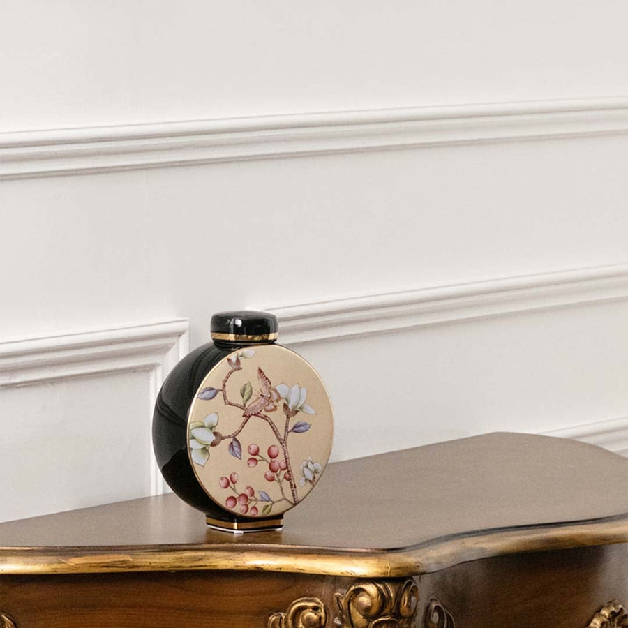 Small black round jar with pastel floral artwork in a front view ideal for artistic décor styling and stylish tabletop accents.