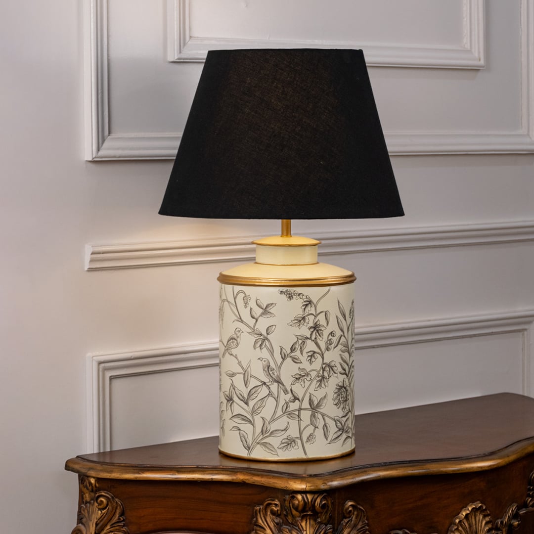 Table lamp featuring a patterned ceramic base with leaf detailing and a black fabric lampshade displayed on a white background.