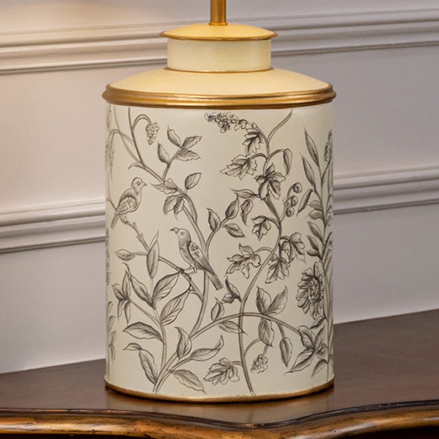 Table lamp closeup highlighting delicate botanical artwork on ceramic base with fine line detailing and smooth glazed finish.