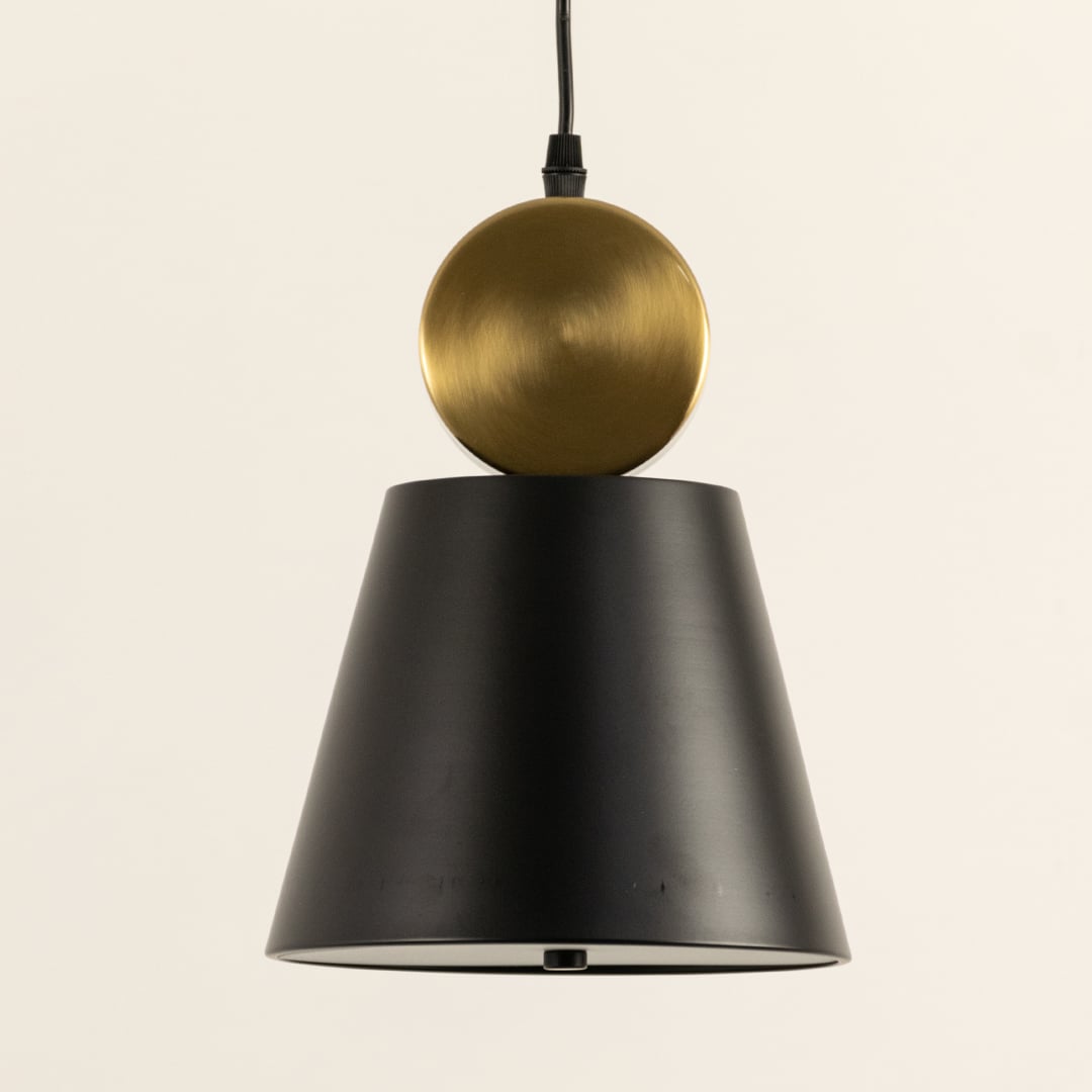 Closeup of metal pendant light showing smooth black tapered shade and spherical metal accent highlighting refined crafted details for modern interior lighting decor.