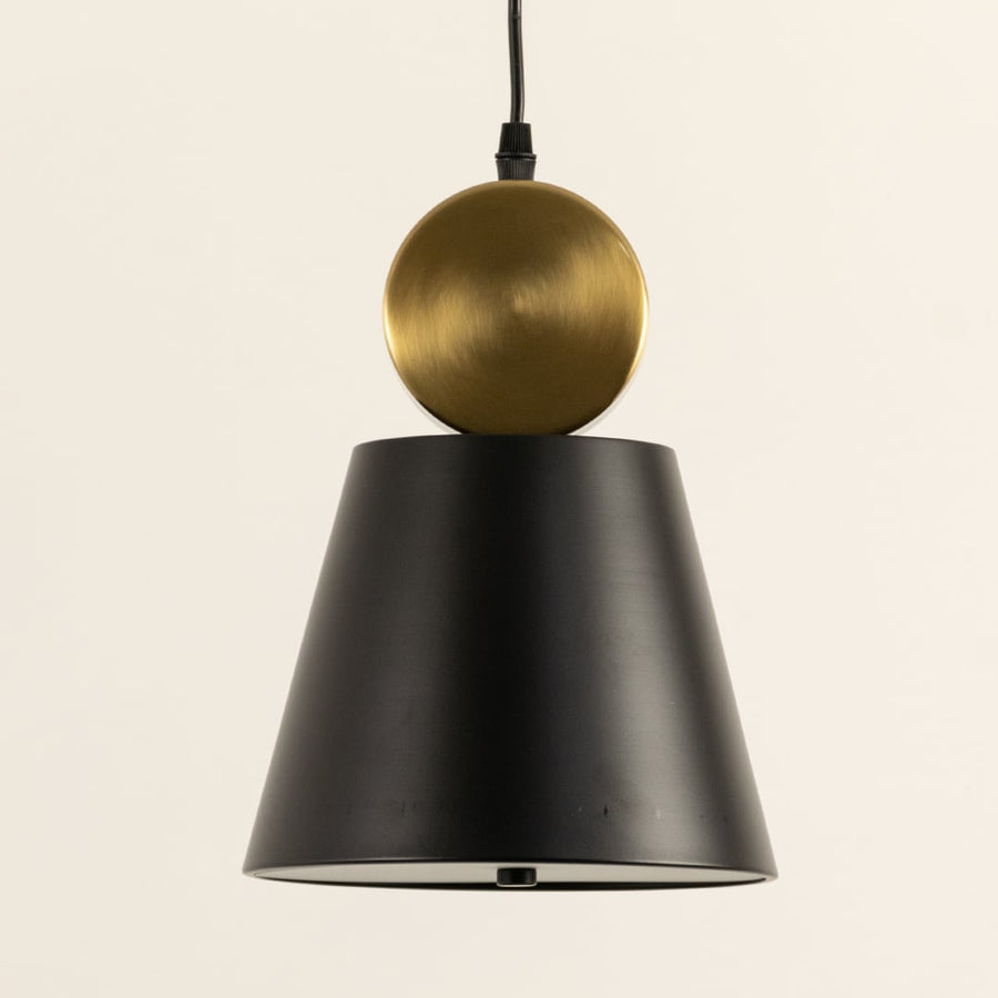 Closeup of metal pendant light showing smooth black tapered shade and spherical metal accent highlighting refined crafted details for modern interior lighting decor.