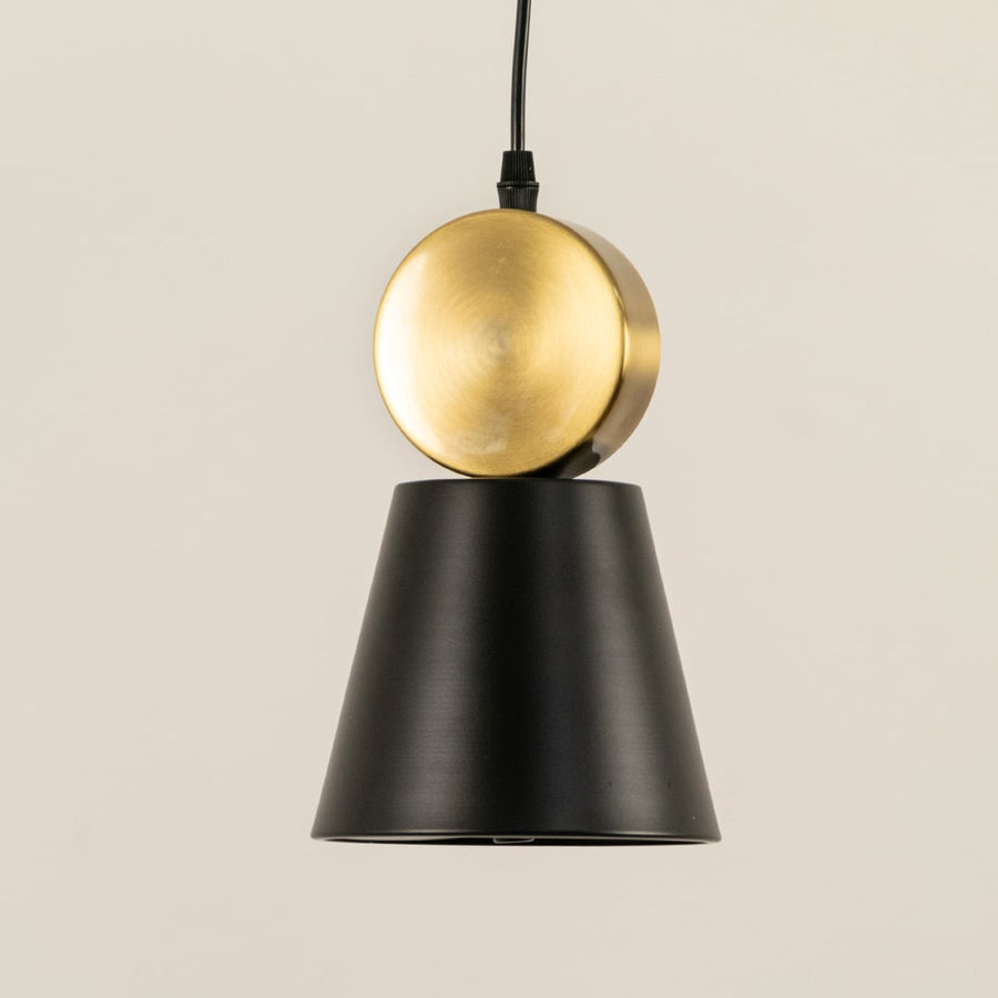 Closeup of metal pendant light highlighting the smooth black tapered shade and rounded metal accent showcasing refined craftsmanship for interior lighting decor.