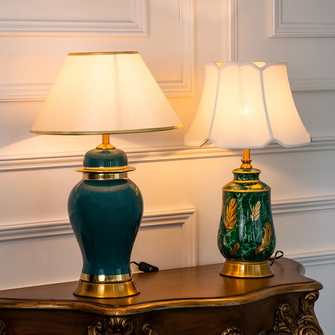 Green ceramic lamps with golden bases and fabric shades turned on glowing in elegant grouped display.