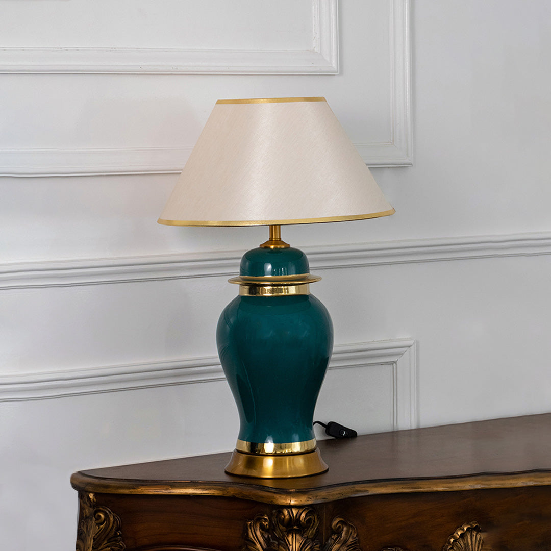 Teal ceramic table lamp with fabric shade and gold accents creating refined traditional lighting for elegant home interiors.