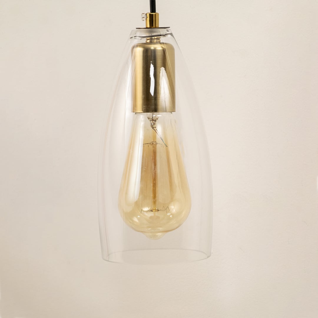 Closeup of brushed gold and clear glass wall light showing detailed metal finish and sleek hanging bulb design for modern interior decor.