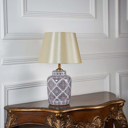 White and gold ceramic table lamp with beige shade shown turned off on white background for elegant home styling.