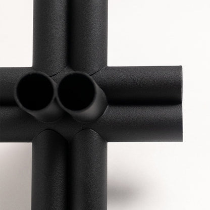 Closeup of black geometric decor sculpture showing matte textured finish and modern artistic detail.