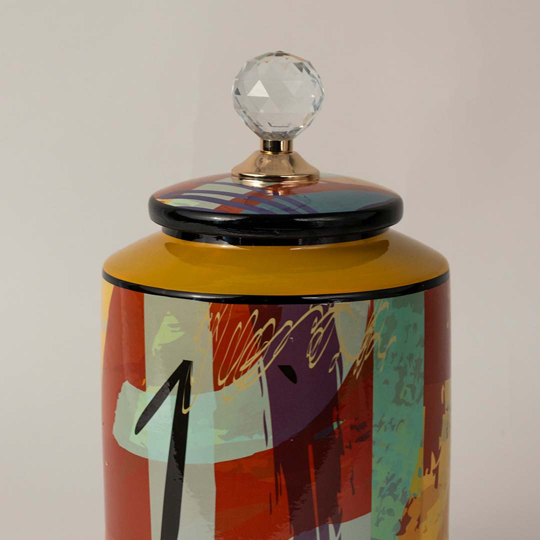 Closeup of colorful ceramic jar showing artistic brush strokes and crystal lid with polished finish.