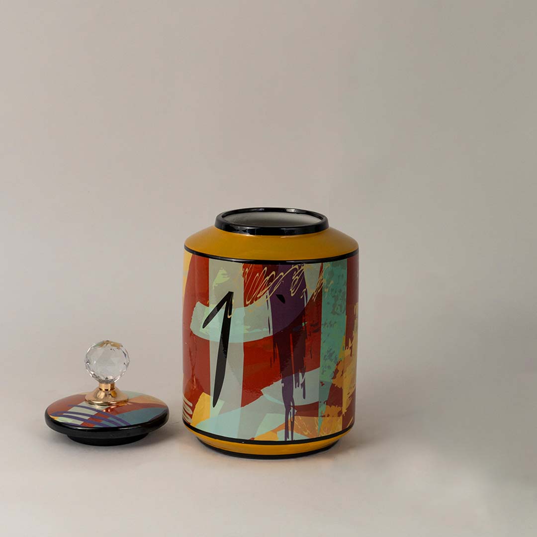 Side angle view of colorful ceramic jar showing bold artistic design and crystal knob detail.