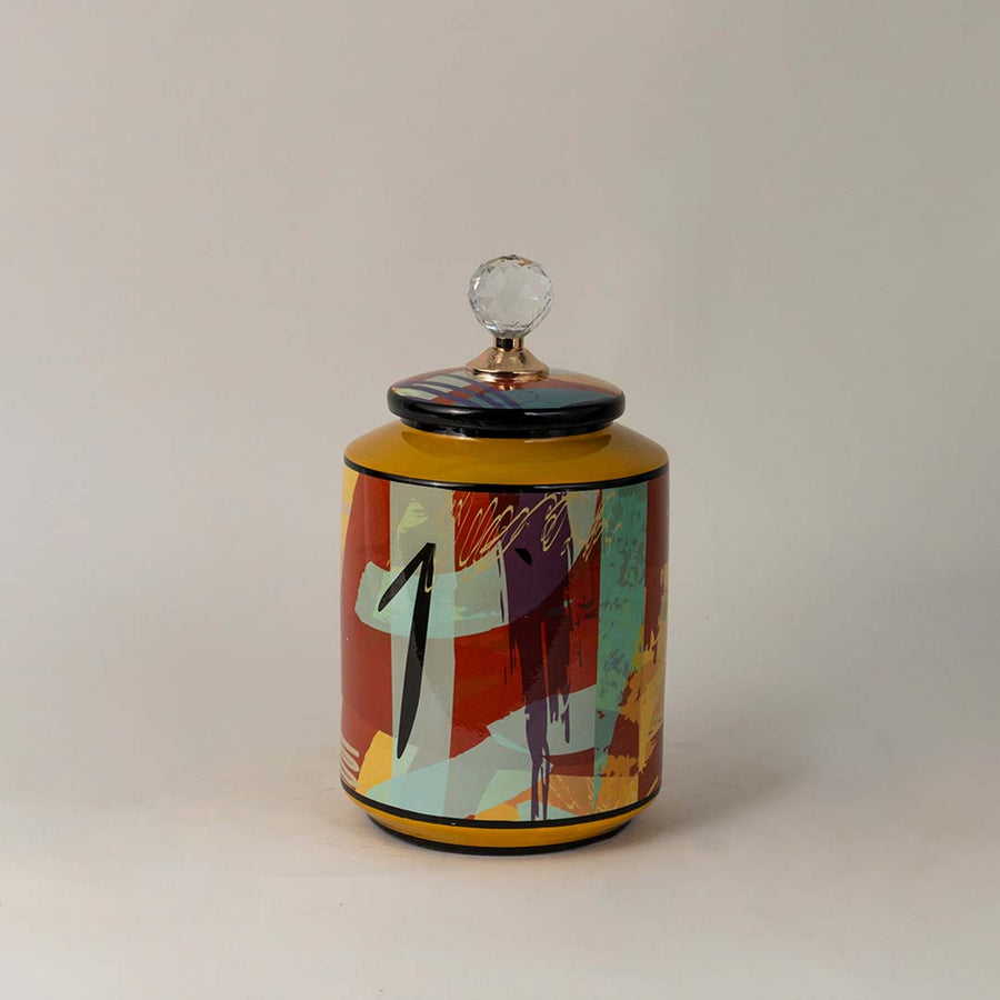 Colorful ceramic jar with cylindrical shape and bright abstract print standing elegantly on a white surface.