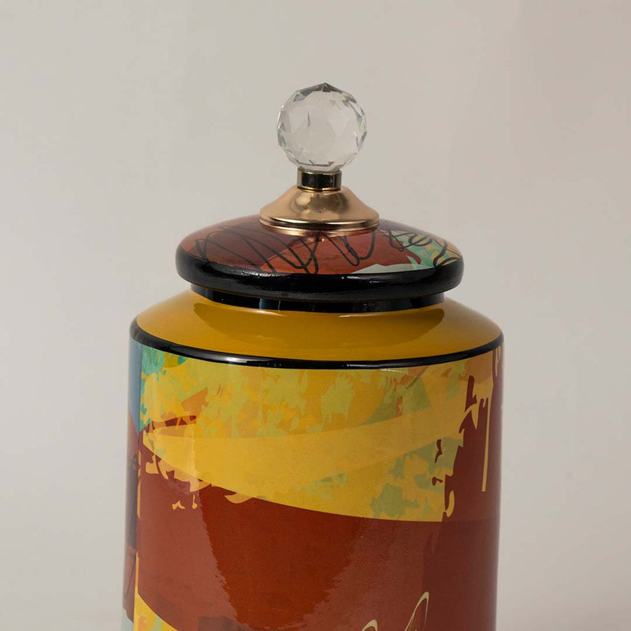 Closeup of multicolor ceramic jar showing fine detailing with a crystal knob lid and glossy artistic texture.