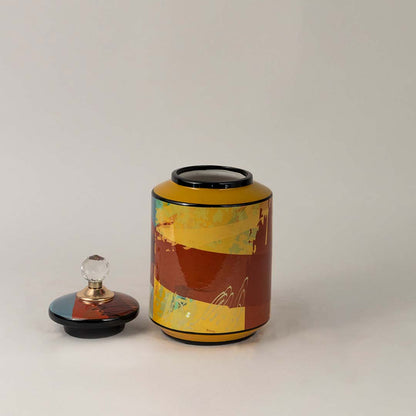 Side angle view of multicolor ceramic jar showing crystal knob lid and dynamic multicolor artwork.
