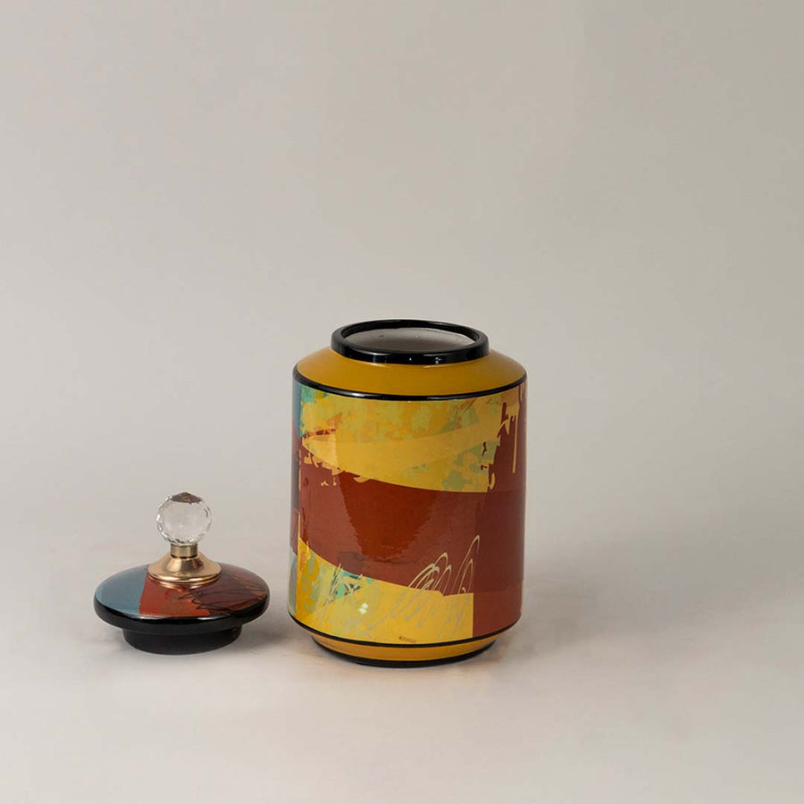 Side angle view of multicolor ceramic jar showing crystal knob lid and dynamic multicolor artwork.