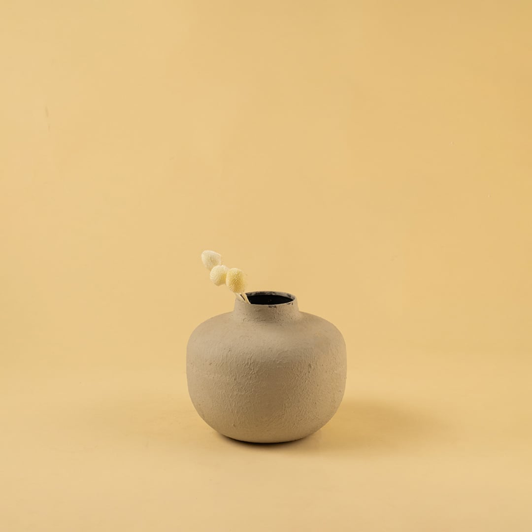 Grey metal textured vase decor styled in a warm modern room adding a subtle elegant accent to living room tables and shelves.