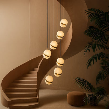 A cascading cluster of spherical pendant lights glowing warmly beside a sweeping curved staircase creating a luxurious modern ambiance in a sculptural interior setting.