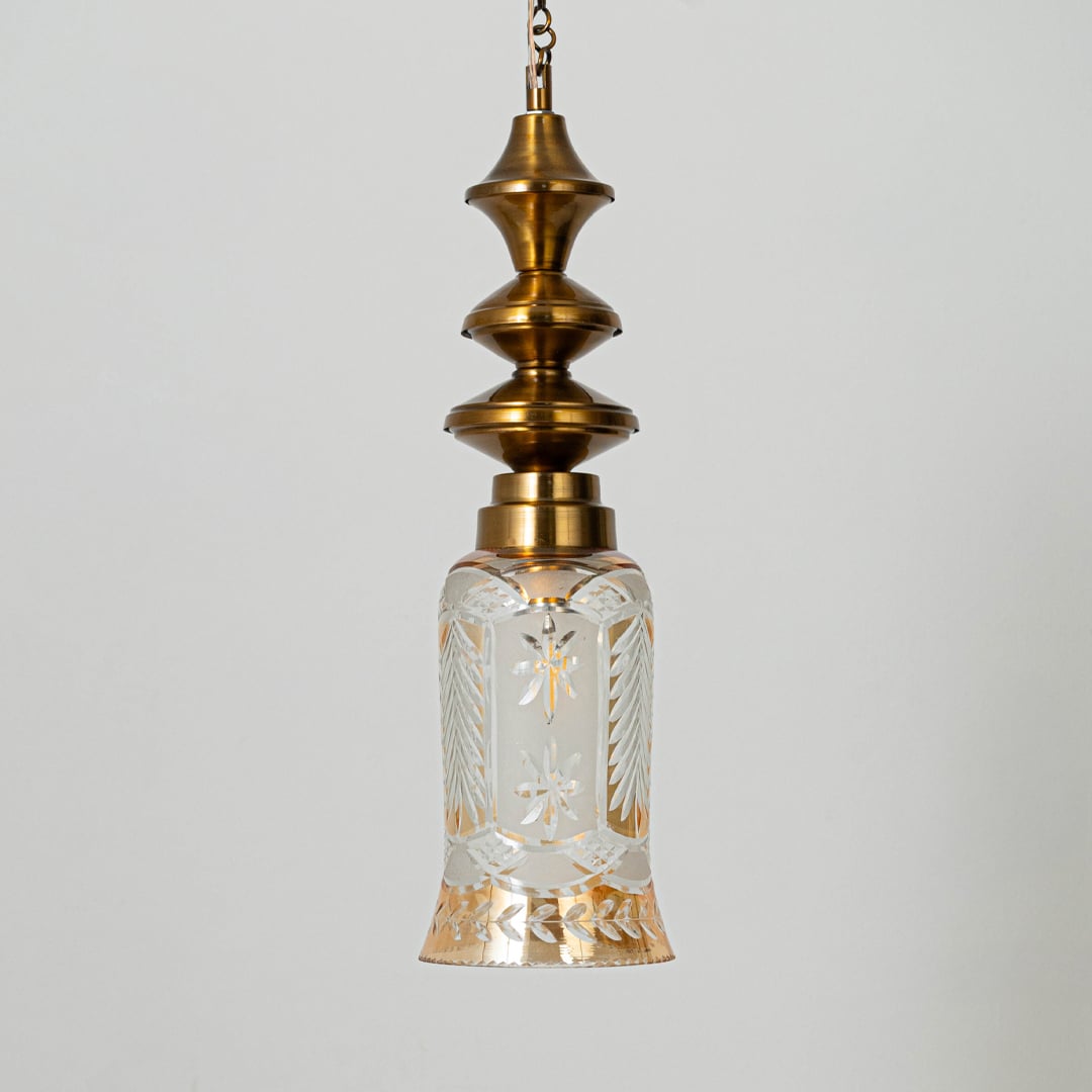 Patterned glass and gold metal pendant light with decorative design for timeless interior styling.