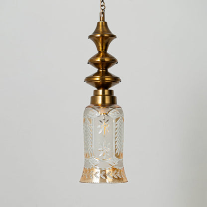 Patterned glass and gold metal pendant light with decorative design for timeless interior styling.