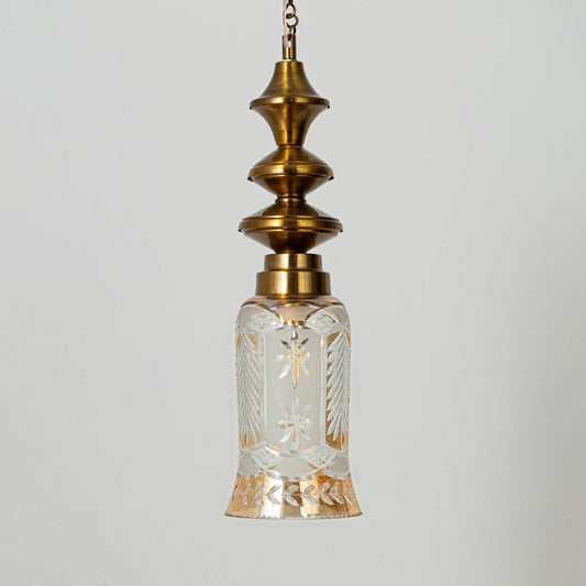 Patterned glass and gold metal pendant light with decorative design for timeless interior styling.