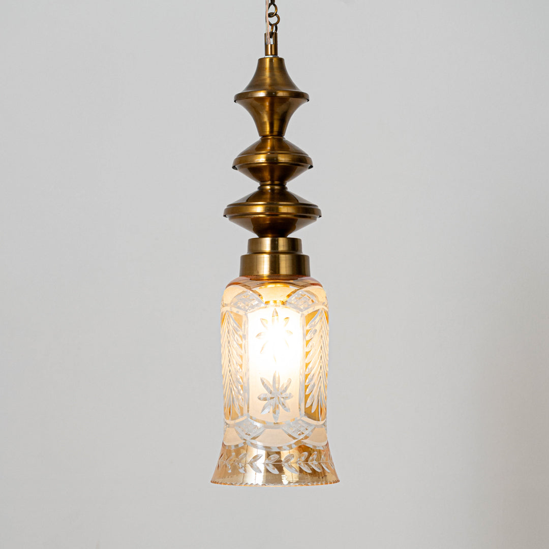 Decorative pendant light in gold metal finish with textured glass shade for dining room or living decor lighting white background.
