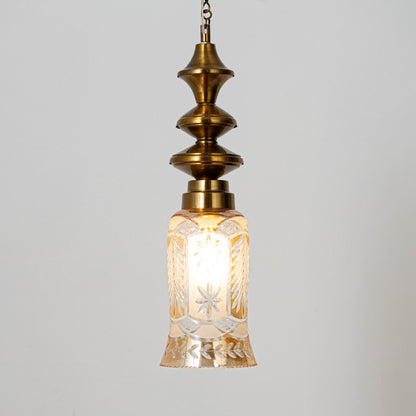 Decorative pendant light in gold metal finish with textured glass shade for dining room or living decor lighting white background.