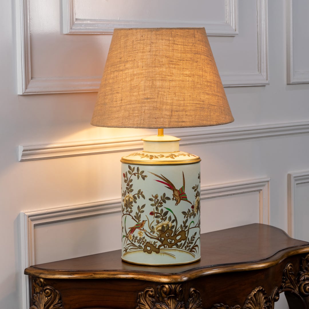 Gilded Phoenix green table lamp on white background with light on creating soothing glow and elegant handcrafted interior decor look.