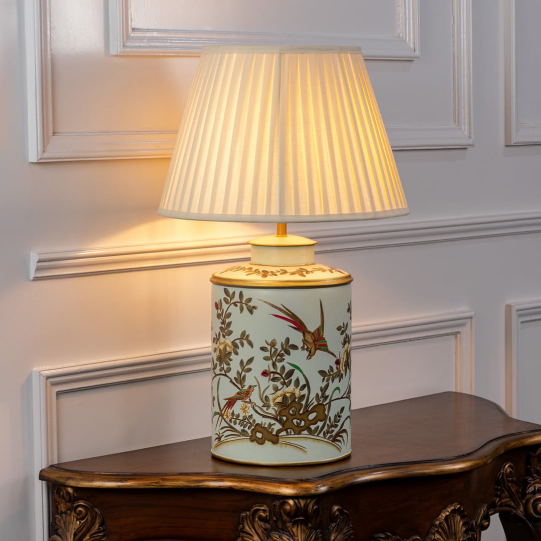 Table lamp with a floral ceramic base and pleated fabric lampshade displayed neatly on a clean white background.