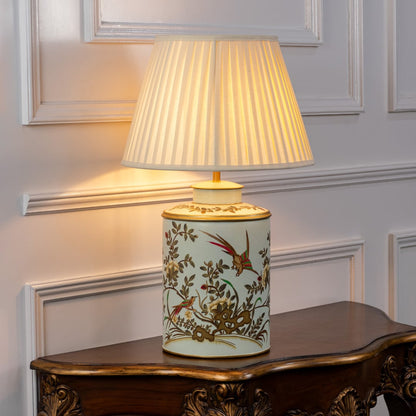 Table lamp with a floral ceramic base and pleated fabric lampshade displayed neatly on a clean white background.