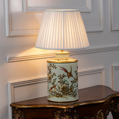 Table lamp with a floral ceramic base and pleated fabric lampshade displayed cleanly on a white background.