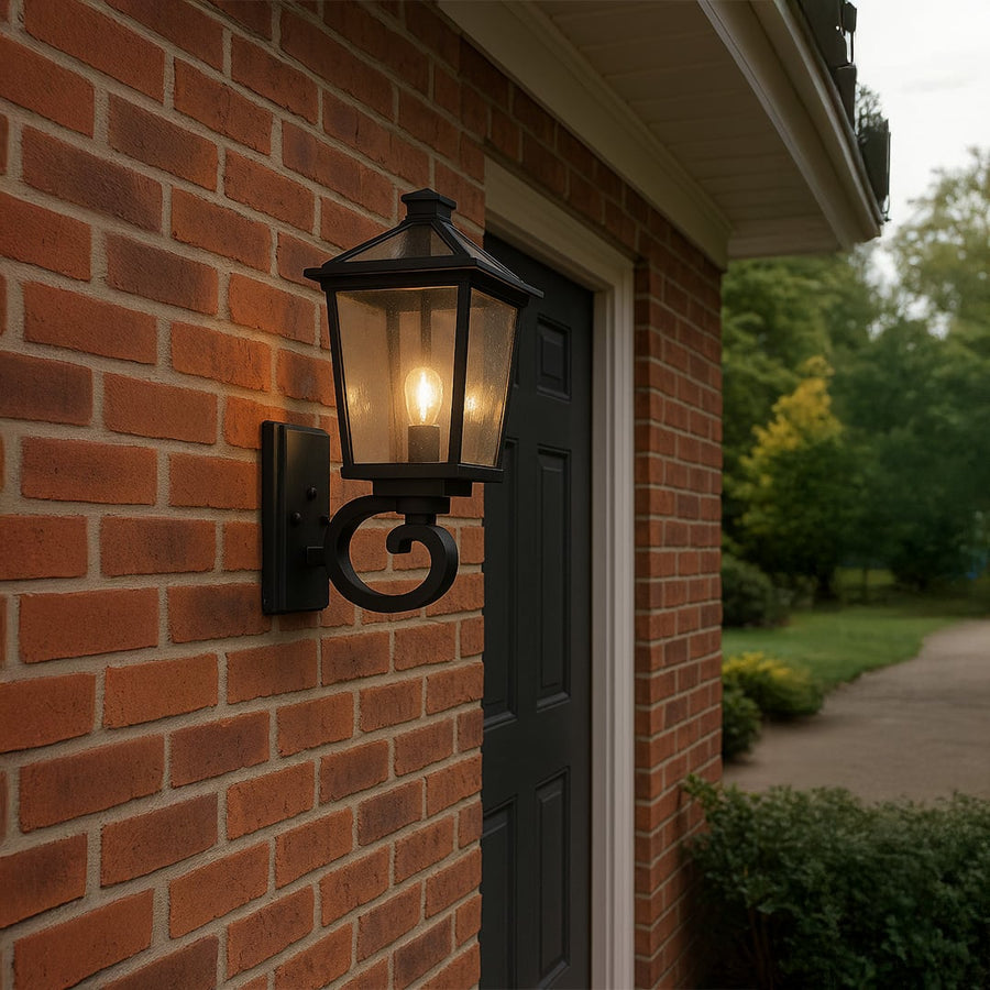 Black outdoor wall lantern with clear textured glass adding warm classic lighting to a modern entryway or garden wall decor.