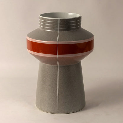 Side angle view of grey ceramic vase with textured matte body and bold red pink stripe perfect for stylish interior decoration.