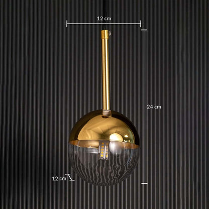 A gold and glass pendant light shown with clear dimensions displaying a 12 cm width a 12 cm depth and a 24 cm height against a dark textured backdrop.