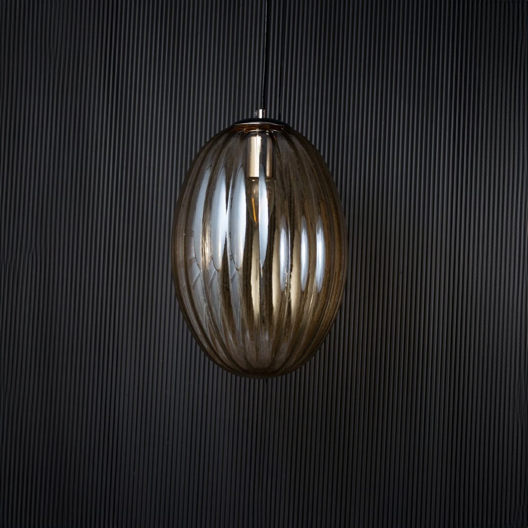 Pendant light turned off against a black background showing its silhouette and smooth finish with clear visibility of its refined contours.