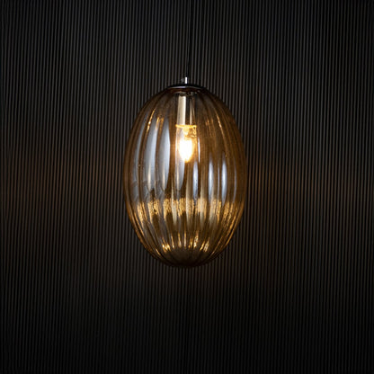 Pendant light turned on against a dark black background creating a soft ambient glow that emphasizes the warm light and elegant structure.