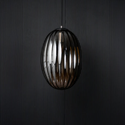 A ribbed oval glass pendant light shown with the light off against a dark background emphasizing the deep reflective finish and sculpted oval design.