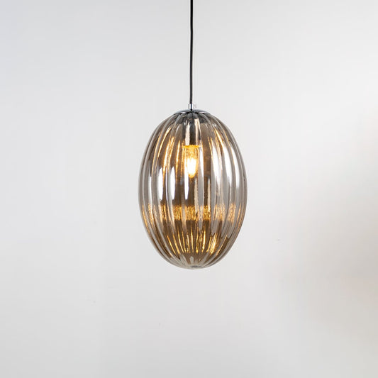 A ribbed oval glass pendant light shown with the light on against a white background displaying its warm illumination and elongated curved form.