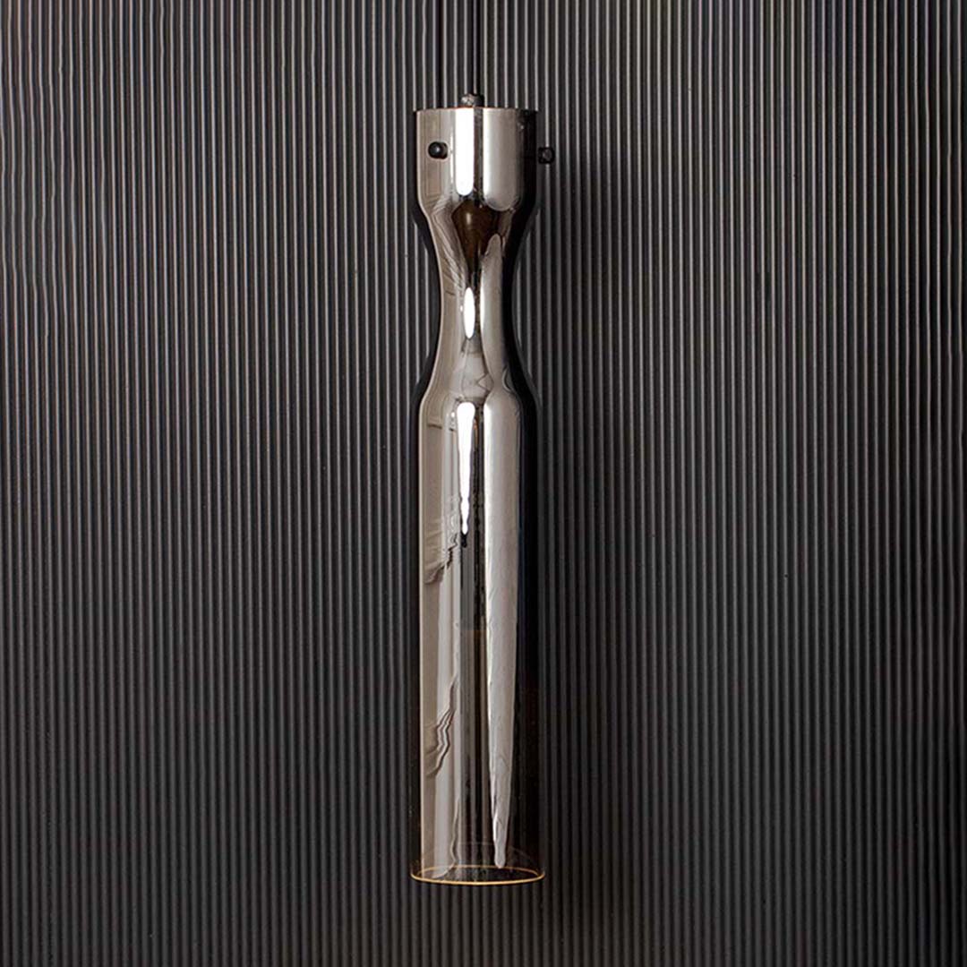 Modern chrome pendant ceiling light illuminated on back background for elegant dining room and cafe interior lighting.