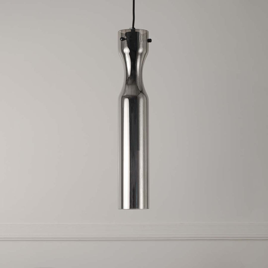 Slim brass pendant light with clear textured glass shade on white background for stylish interior lighting.