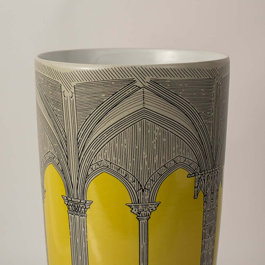 Closeup view of yellow and grey ceramic vase showing intricate arch design and smooth matte finish for interior styling.