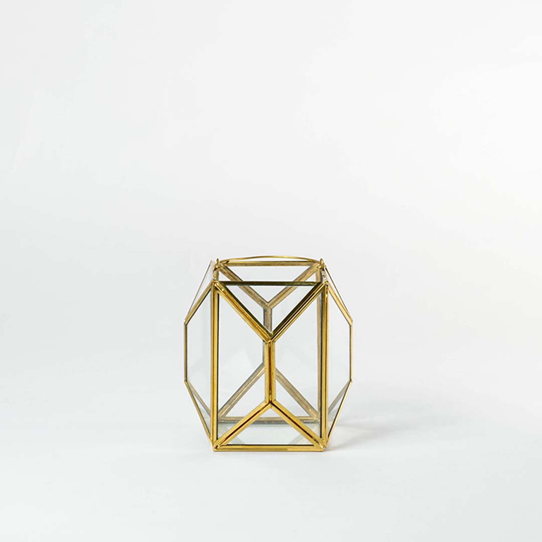 Gold metal geometric candle holder with open frame structure for modern tabletop decor styling.