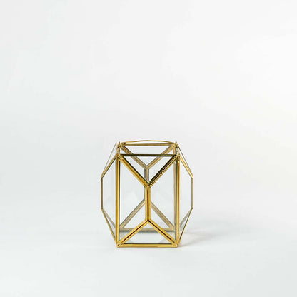 Gold metal geometric candle holder with open frame structure for modern tabletop decor styling.