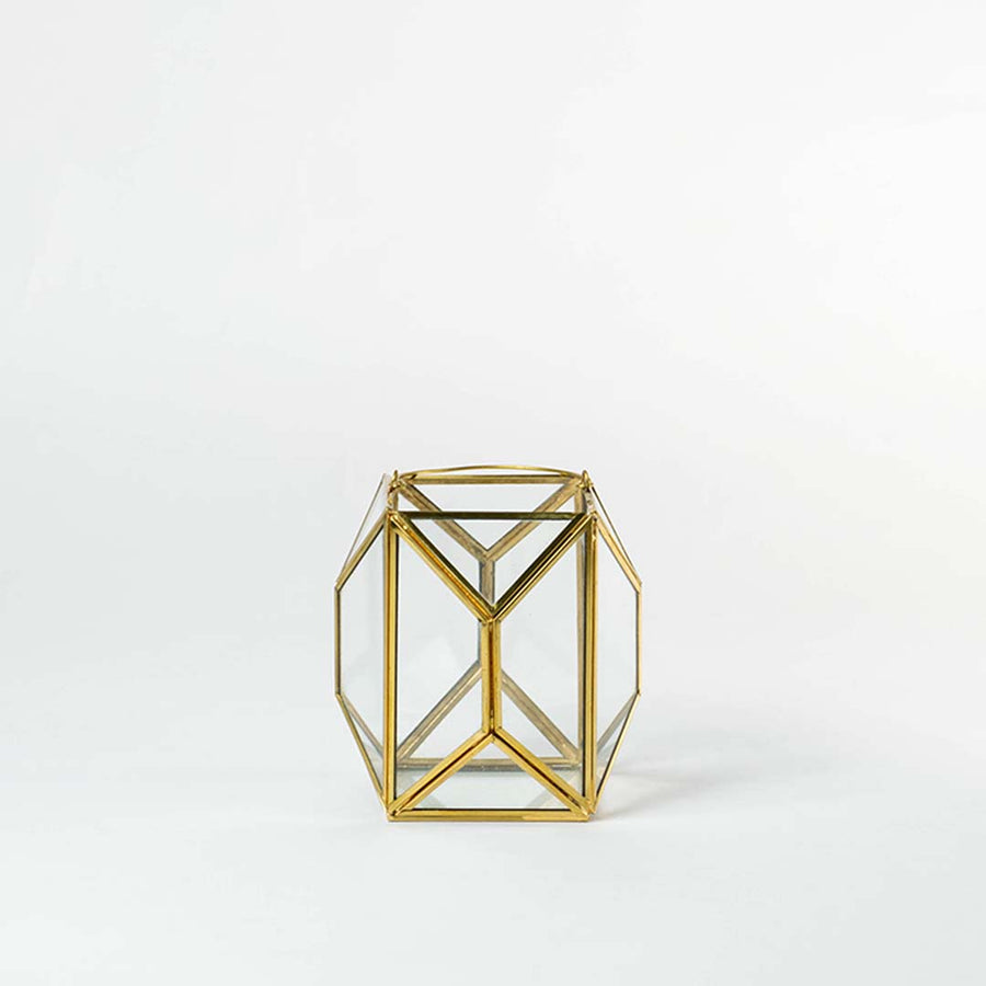 Gold metal geometric candle holder with open frame structure for modern tabletop decor styling.