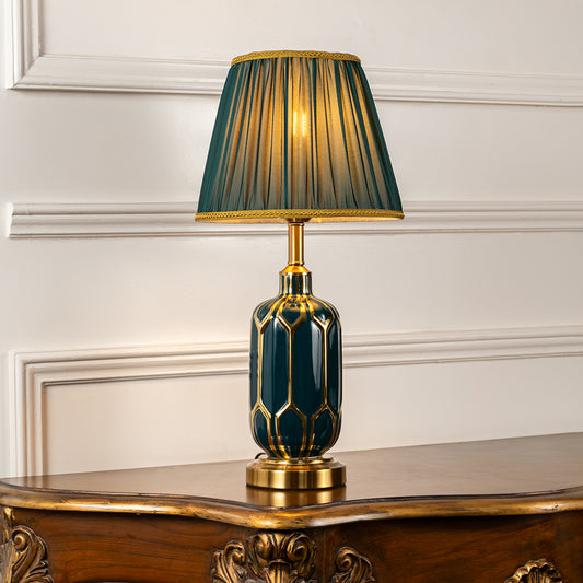 Table lamp with green fabric shade and textured base ideal for bedroom or living room table decor styling on clean background.