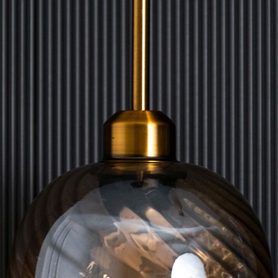 Detailed view of swirled glass texture and brushed gold finish of hanging pendant lamp showing high quality craftsmanship and design.