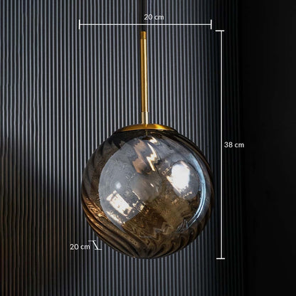 A gold and amber glass pendant light shown with 20 cm width 20 cm depth and 38 cm height measurements highlighting its compact round design.