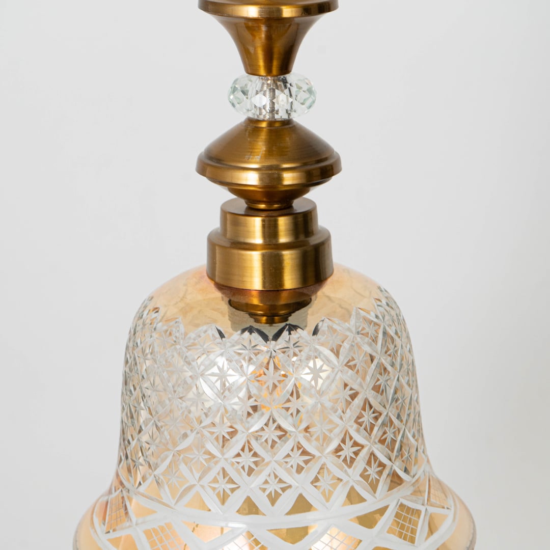 Detailed view of patterned glass and gold metal pendant light highlighting ornate craftsmanship and texture.