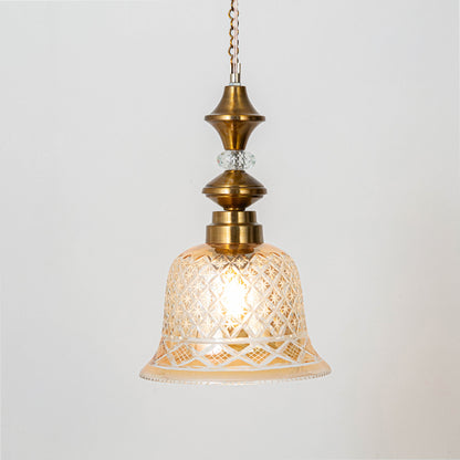 Classic pendant light in gold metal finish with patterned glass shade for dining room or living decor lighting white background.
